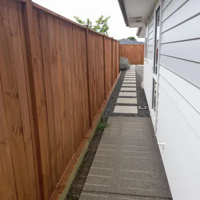 The stained fence running down the side path