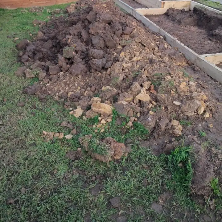 A big pile of lumpy clay dug out of the front lawn, beside the new timber frames